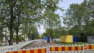 Puistoon on rakenteilla tie työmaa-aitojen takana.